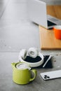 Green teapot, headphones, smartphone and notepad on a blurred background. Royalty Free Stock Photo