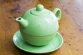 Green teapot on a wooden kitchen surface