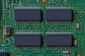 Green technology background. Closeup detail image of four big chip with a lot of legs on green digital electronic circuit board Royalty Free Stock Photo