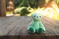 Green teddy bear on wood floor with blurred green background