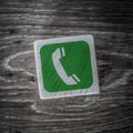 A green telephone or mobile phone sign, symbol or icon on a wooden block with copy space Royalty Free Stock Photo