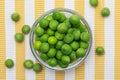 Green, tender, fresh and raw peas. In wicker basket.