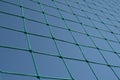 Green tennis or volleyball net against blue sky. Grid pattern abstract background Royalty Free Stock Photo