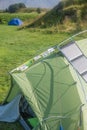 Green tent of a hiker with many stay stickers and a solar panel in Iceland, closeup, details, summer