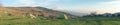 Green tent on a meadow and smoking Etna Volcano pano view