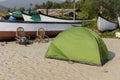 Green tent and old wicker chairs next to fishing boats on the beach in Goa in India Royalty Free Stock Photo