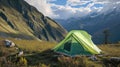 A green tent pitched up in the mountains
