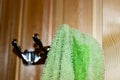 A green Terry towel hangs on a hanger on the wooden wall Royalty Free Stock Photo