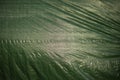 Green texture made of plastic fabric. Green awning. Uneven surface