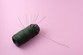 green thread with group of needle isolated pink background Royalty Free Stock Photo