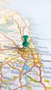 A green thumb tack pinned into Newcastle upon Tyne on a map of England portrait