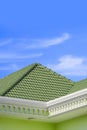 Green tile roof with white ornamental eaves of modern house against cloud on blue sky background Royalty Free Stock Photo