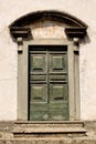 Green timber door entrance to a historic old building in the tiny rural village of Benabbio