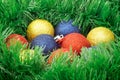 Green tinsel garland around Christmas balls as nest. Selective focus. Royalty Free Stock Photo