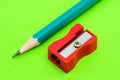 The green tip of the pencil and the red sharpener lie on a green background Royalty Free Stock Photo