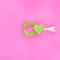 Green toast with heart in it on a pink background with fork. Healthy food flat lay aesthetic idea. Valentine breakfast concept Royalty Free Stock Photo