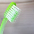 Green toothbrush close-up on a light wooden background