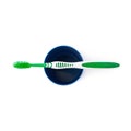 Green toothbrush with paste lying on blue plastic cup isolated over white background Royalty Free Stock Photo