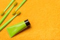 Green toothbrushes with paste tube on yellow bath towel. Importance of oral health care