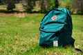 Green tourist backpack on a lawn background in the mountains, travel concept in the wild, closeup Royalty Free Stock Photo