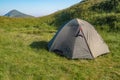 Green tourist tent in camp among meadow in the mountain.Nature background Royalty Free Stock Photo