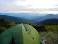 Green tourist tent in ukrainian mountains with a view to forested hills