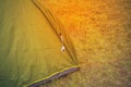 Green touristic tent among grass , on grassland, forest camp