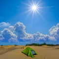 green touristic tent stay among sandy prairie at hot sunny day