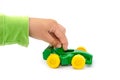 Green toy car in a child`s hand isolated on a white background. Hand is playing with a toy car on white. Royalty Free Stock Photo