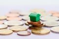 Green toy house on instable stack of coins symolizing bad economy.. Royalty Free Stock Photo