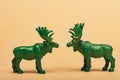 Green toy mooses on yellow background