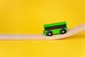 Green toy wagon of train goes up isolated on yellow background Royalty Free Stock Photo