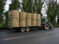 Green tractor with bales of straw