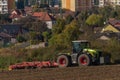 Green tractor plough brown autumn field near Steti town