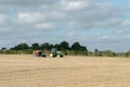 A green tractor with a seed drill in a stubble field Royalty Free Stock Photo