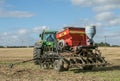 A green tractor with a seed drill in a stubble field Royalty Free Stock Photo