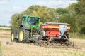 A green tractor with a seed drill in a stubble field Royalty Free Stock Photo