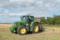 A green tractor with a seed drill in a stubble field Royalty Free Stock Photo