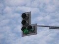 Green traffic light with an additional section against a cloudy sky Royalty Free Stock Photo