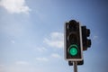 Green traffic light. Blue sky with few clouds background. Close up under view, copyspace. Royalty Free Stock Photo
