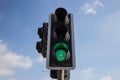 Green traffic light . Blue sky with few clouds background. Close up under view. Royalty Free Stock Photo