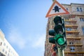 Green traffic light and traffic sign. Signal for safety route. Blue sky background. Closeup under view, space Royalty Free Stock Photo