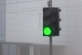Green traffic light in thick fog. Traffic regulation_