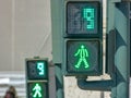 2 green traffic lights for pedestrians on the crosswalk counting down in 9 second. Royalty Free Stock Photo