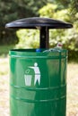 Green trash basket with sign pictogram.