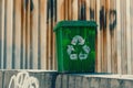 A green trash can with a white recycling symbol on it