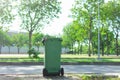 Green trash in the garden. Moulded plastic, wheeled waste bin in The park. Trash or bin is tools of Waste management. Royalty Free Stock Photo