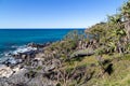 Staircase leading down to rock and sand filled beach with beautiful blue ocean Royalty Free Stock Photo