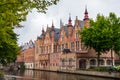 Green trees and historic buildings next to a canal in Bruges