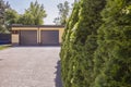 Green trees on the property of house with garage and stone road Royalty Free Stock Photo